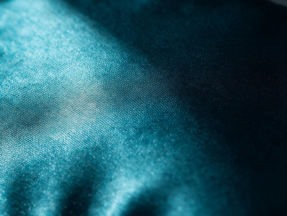Side profile of the Lunia Reve sleep mask in Fathom showing the contoured shape holding space away from the eyes